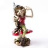 A whimsical figurine of a Pesky Cornish Piskie sitting confidently atop a large, colorful mushroom. The character has a playful expression,
