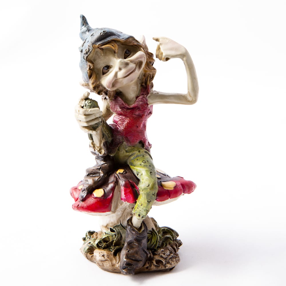 A whimsical figurine of a Pesky Cornish Piskie sitting confidently atop a large, colorful mushroom. The character has a playful expression,