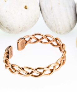 Magnetic copper therapy bracelet in an open cuff style, featuring an elegant woven braid design crafted from polished copper, with magnets set at each end for potential arthritis relief, improved blood circulation, and overall wellness benefits.