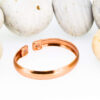 Magnetic copper therapy bracelet in a sleek open cuff design, crafted from polished solid copper with a smooth minimalist finish, featuring magnets at each end for potential arthritis relief, enhanced circulation, and overall wellness, displayed against smooth white pebbles.
