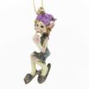 Charming Cornish Pesky Pisky seated in a playful pose. The Cornish Pisky wears a stylish outfit, complete with a playful purple hat and sparkly shoes