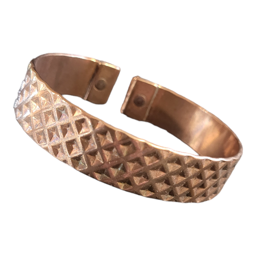 Solid copper magnetic bracelet in an open cuff design, featuring a textured diamond-pattern surface and magnets embedded at each end for potential wellness benefits.
