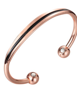 A polished copper open cuff bangle with a sleek black enamel stripe running along its outer curve. The design is finished with smooth rounded ball ends, each inset with a circular magnet, combining modern elegance with potential magnetic therapy benefits.