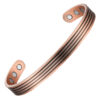 A copper open cuff bangle featuring a series of fine parallel grooves running along its length for a textured, striped effect. The ends are rounded discs inset with large magnets, with additional smaller magnets positioned on the inner surface near each end, combining detailed craftsmanship with potential magnetic therapy benefits.