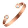 A copper open cuff bangle featuring a series of fine parallel grooves running along its length for a textured, striped effect. The ends are rounded discs inset with large magnets, with additional smaller magnets positioned on the inner surface near each end, combining detailed craftsmanship with potential magnetic therapy benefits.