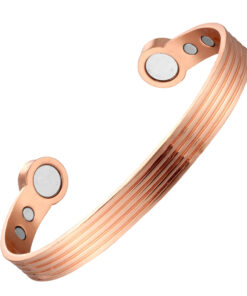 A copper open cuff bangle featuring a series of fine parallel grooves running along its length for a textured, striped effect. The ends are rounded discs inset with large magnets, with additional smaller magnets positioned on the inner surface near each end, combining detailed craftsmanship with potential magnetic therapy benefits.