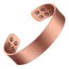 A wide copper open cuff bangle with a smooth, brushed matte finish for a clean and minimalist look. The interior features multiple round inset magnets—three on each end—designed to combine simple elegance with potential magnetic therapy benefits.