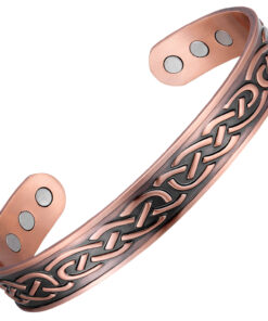 A copper open cuff bangle featuring an engraved Celtic knot pattern with darkened antique detailing for contrast. The interior is smooth and fitted with multiple round inset magnets near each end, blending traditional Celtic artistry with potential magnetic therapy benefits.