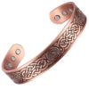 A copper open cuff bangle featuring an intricate engraved Celtic knot pattern interspersed with circular medallions displaying a lion emblem. The antique-style darkened detailing enhances the design, while the smooth interior is fitted with multiple round inset magnets near each end, combining traditional craftsmanship with potential magnetic therapy benefits.