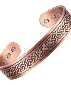 A copper open cuff bangle featuring an engraved Celtic knot pattern running continuously along its length. The design is accented with a darkened antique finish, while the smooth interior contains multiple round inset magnets near each end, blending traditional artistry with potential magnetic therapy benefits.