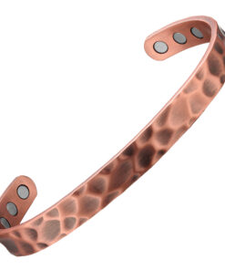 A slim copper open cuff bangle with a hammered texture, creating an uneven dimpled surface for a rustic yet stylish appearance. The inner side is smooth and fitted with multiple round inset magnets near each end, combining artisanal design with potential magnetic therapy benefits.
