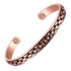 A copper open cuff bangle featuring a central black-accented chain-link pattern running along its length. The interior is smooth and includes a single round inset magnet near each end, combining bold industrial-inspired design with potential magnetic therapy benefits.