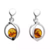 Sterling silver dangle earrings featuring round Baltic amber stones set in an open modern silver frame.