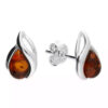 Sterling silver stud earrings featuring teardrop-shaped Baltic amber stones in a modern silver twist design.