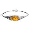 925 sterling silver bangle bracelet featuring an oval amber gemstone with natural inclusions set in an elegant openwork design.
