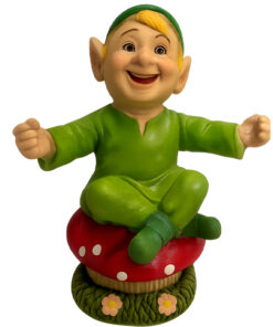 Cheerful Cornish piskey figurine in a green outfit sitting cross‑legged on a red spotted mushroom with colourful flowers at the base.