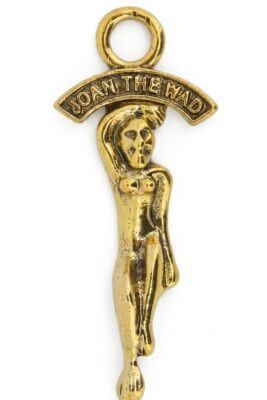 A traditional gold-colored metal Joan the Wad good luck pocket charm from Cornwall, shown flat on a solid white background. This authentic representation of the Cornish piskie queen serves as a historic UK folklore amulet and collectible souvenir.