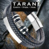 A Taran men's multi-strand black leather bracelet featuring three distinct layers: a smooth band with a curved silver stainless steel bar, a round-braided strand, and a center strand stacked with polished silver-toned geometric beads. The piece includes a high-shine silver magnetic clasp, displayed against a rugged, dark textured stone and rustic slate background with the Taran logo.