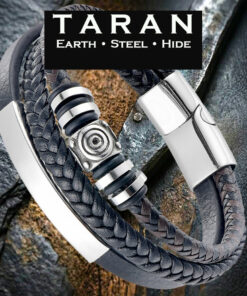 A Taran men's multi-strand black leather bracelet featuring three distinct layers: a smooth band with a curved silver stainless steel bar, a round-braided strand, and a center strand stacked with polished silver-toned geometric beads. The piece includes a high-shine silver magnetic clasp, displayed against a rugged, dark textured stone and rustic slate background with the Taran logo.